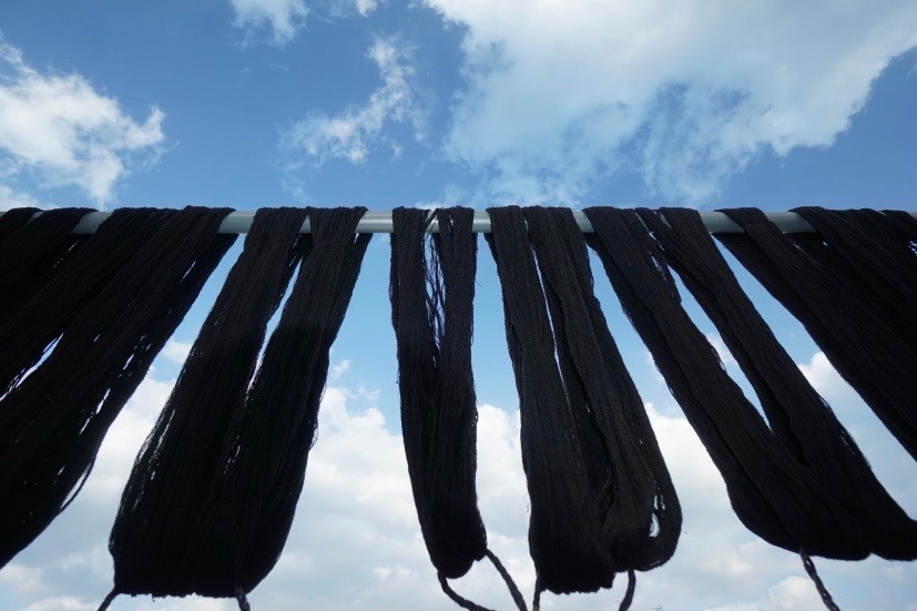 次の泥染の工程を経た久米島紬の絹糸