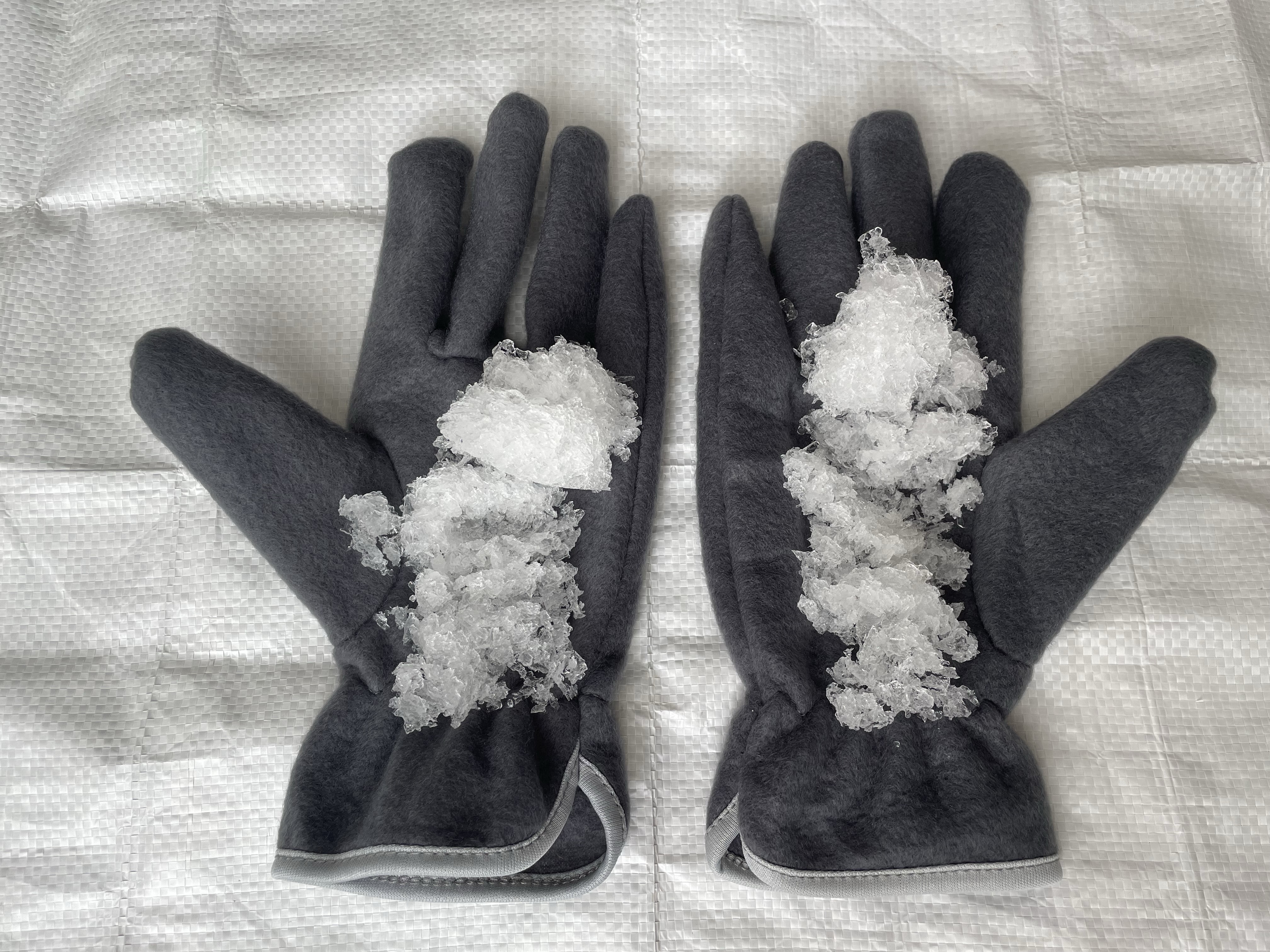 「実験:画像右側の手袋だけ防水スプレーをし噴霧し、かき氷の擬似雪をのせました。」