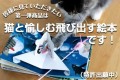 絵本と専用猫じゃらしを眺める猫