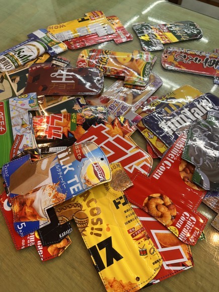 お菓子の袋や役目を終えたポスターから革小物へ
