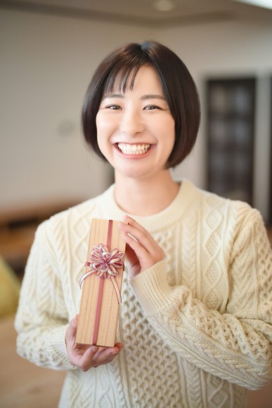 結婚相手を好きになりプレゼントを渡す笑顔の女性