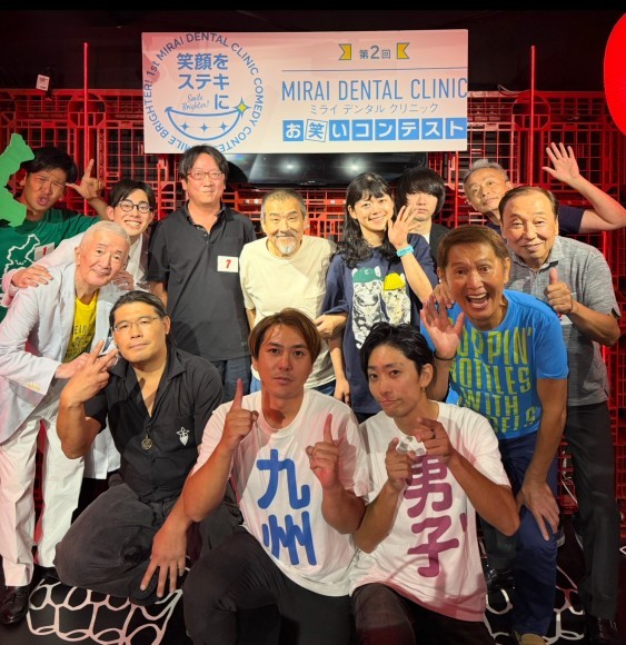 第二回決勝メンバーとMCの九州男子”(左からやったーくん、ペンた丸、ホープ師匠、ぽーとぴあ　中央　九州男子”、西田和昭さん、ピース師匠、ハイランド、なまえ、青木イサムさん）