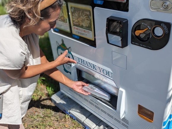 冷凍食品自動販売機から購入した商品を取る様子