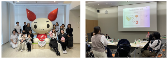 けんけつちゃんの前で座談会に参加したママと記念撮影。スライドで説明を受けている様子。