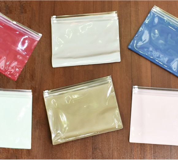 廃棄処分となる手帳カバーの原反を再利用したクリアポーチ「大きくまとめるんです」３つのポケットに防災用品や衛生用品を収納し、万一に備える事ができる。