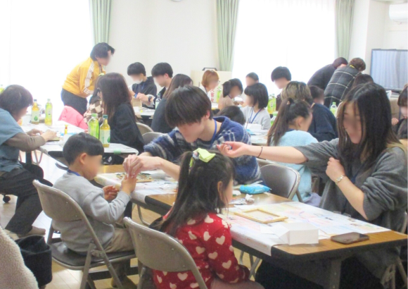 廃材を使って写真立てを作る大学生と小学生