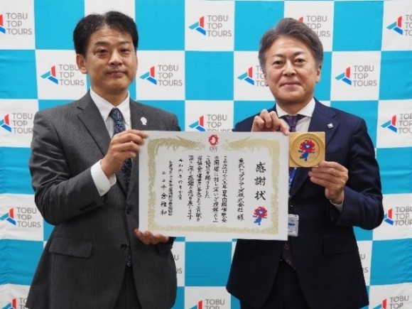 博覧会協会企画局の佐藤企画部長より感謝状を受領する東武トップツアーズ脇坂副社長